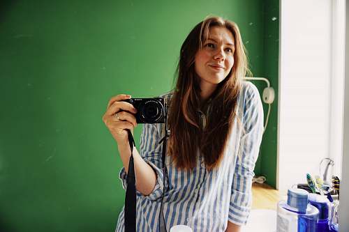 person women's white and gray striped button-up shirt camera