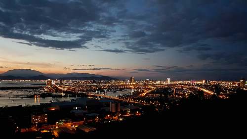 nature city with high-rise buildings viewing sea during night time outdoors