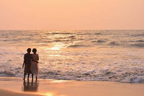 water two women standing on shoreline ocean