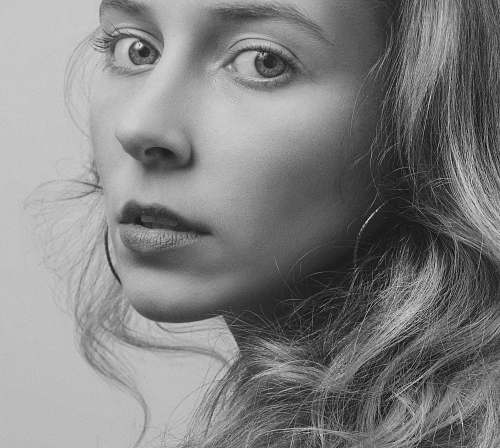 face grayscale photo of woman wearing hoop earring black-and-white