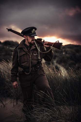 human man carrying rifle outdoors people