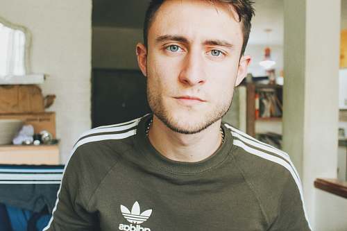 human man wearing black adidas crew-neck shirt apparel