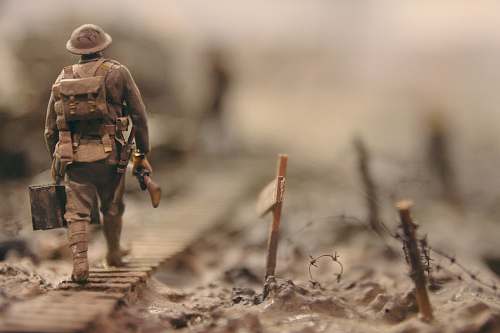 human soldier walking on wooden pathway surrounded with barbwire selective focus photography people