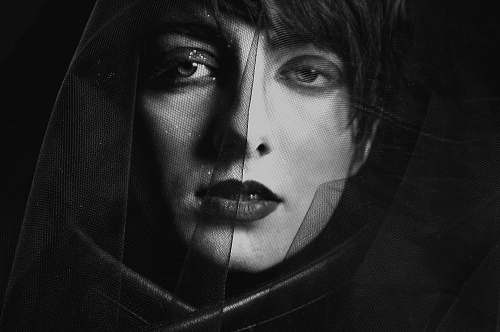 black-and-white woman covering her face with mesh textile face