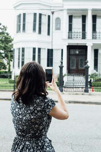 human woman taking photo of house phone