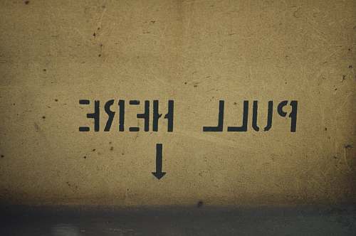 cardboard pull here with arrow pointing downwards sign grey