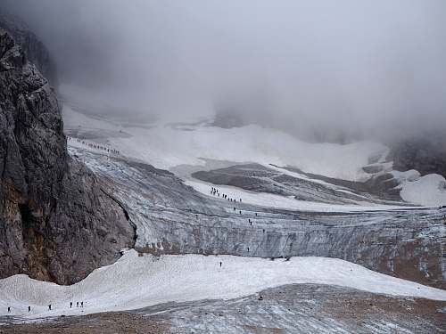 snow group of people walking on mountain trail under sea of clouds mountain