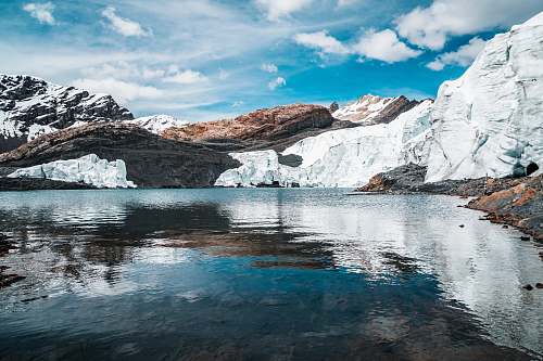 ice rippling body of water near mountains mountain