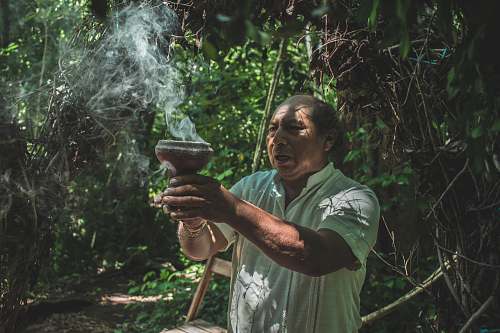 person man holding brown pot with smoke people