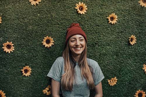 apparel smiling woman leaning on floral wall clothing