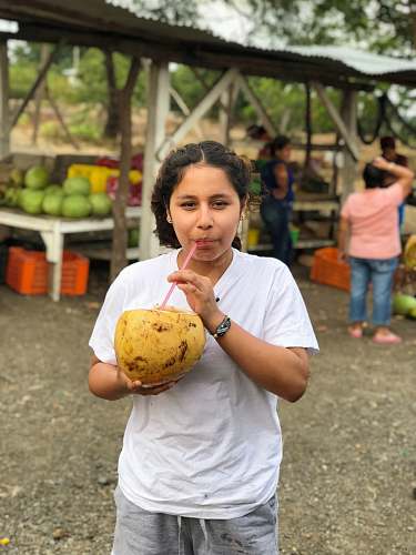 person woman sipping coconut fruit people