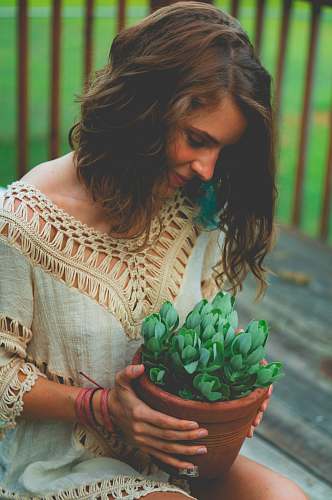 person woman sitting while holding pot of succulent plants people