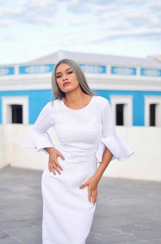 clothing woman standing near blue building apparel