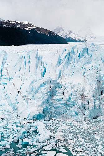 ice iceberg near mountain at daytime snow