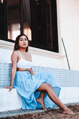 clothing barefooted woman sitting near white wall robe