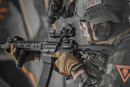 clothing close-up photography of person holding rifle helmet