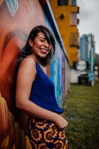 clothing laughing woman leaning on wall fashion