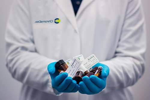 clothing person holding amber glass bottles lab coat
