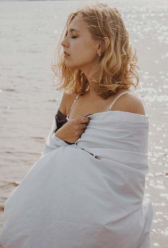 clothing woman closing eyes standing near sea robe