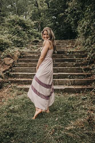 clothing woman in gray walking towards the stairs evening dress