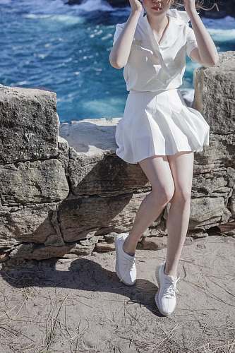 clothing woman sitting on concrete rail footwear