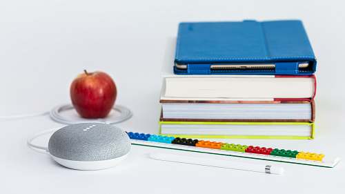food honeycrisp apple fruit near books and chalk Google Home Mini smart speaker fruit