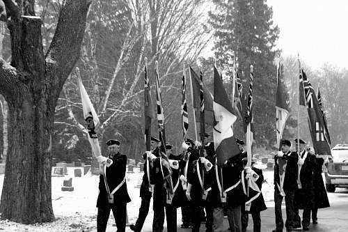 human grayscale photo of people marching while holding flags person