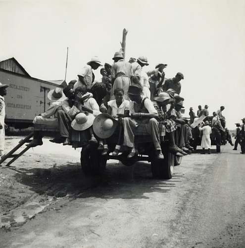 machine grayscale photography of people riding truck wheel
