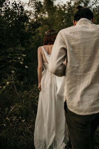 apparel man and woman sitting beside plants robe