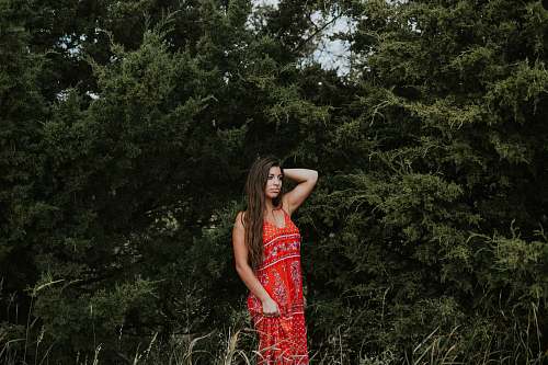 apparel standing woman wearing red sleeveless dress during daytime gown