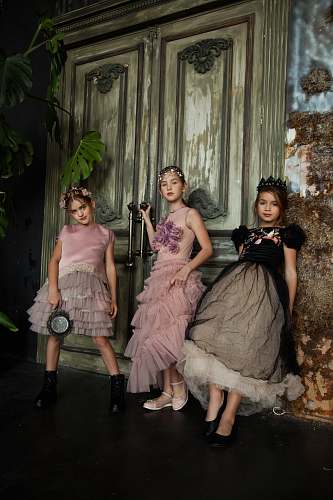 apparel three girls wearing dresses in front of closed door robe