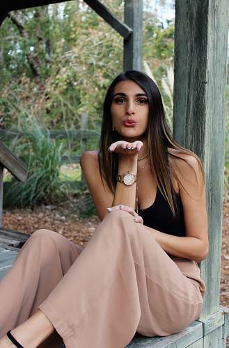 apparel woman making flying kiss post while sitting robe
