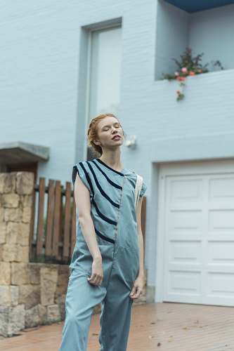 apparel woman standing near house fashion