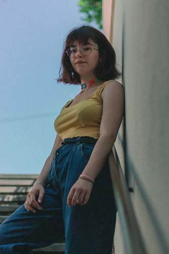apparel woman standing on stairs leaning on wall fashion