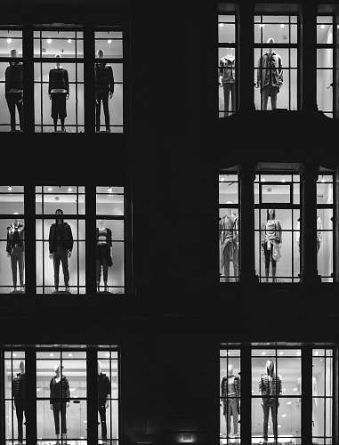 black-and-white mannequin in front of windows black