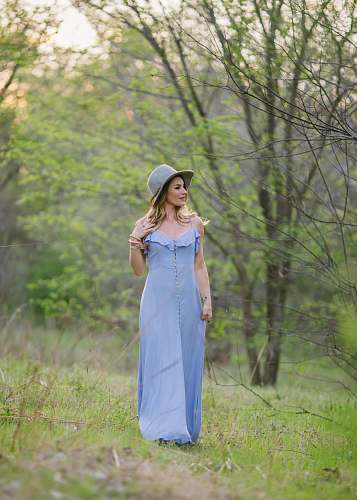apparel woman in blue dress and gray hat standing on green grass clothing