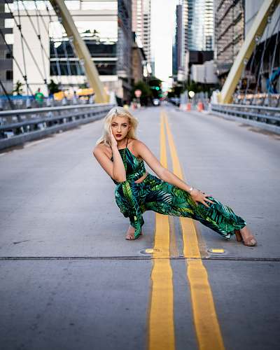 apparel woman in green rompers squatting in middle of bridge clothing