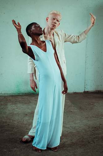 clothing woman in white sleeveless dress behind man in beige dress shirt apparel