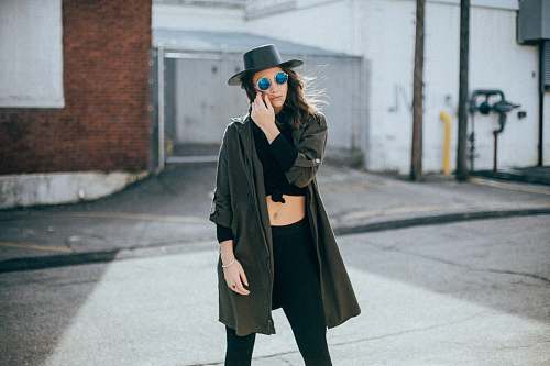person woman standing behind white and brown concrete wall people