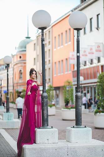 clothing woman standing beside black and white street post apparel