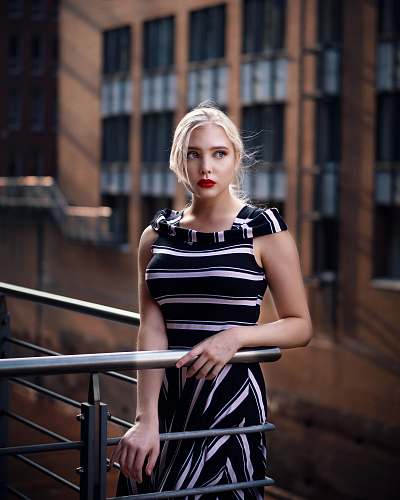 banister woman standing beside railway handrail