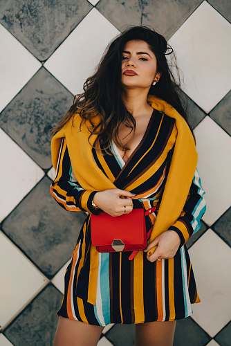 clothing woman standing while wearing yellow and black striped dress apparel