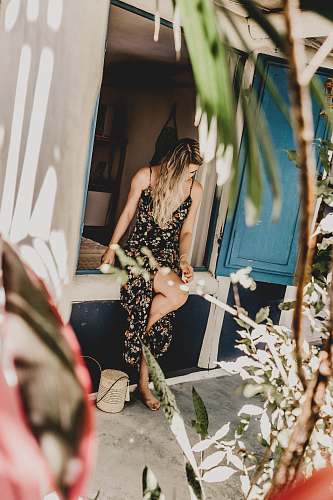 clothing woman wearing floral dress sitting on window apparel