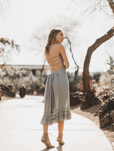 apparel woman wearing gray halter dress standing on pathway clothing