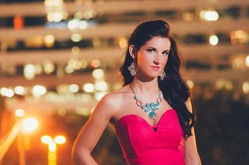 person woman wearing red sweetheart neckline top with bokeh lights human