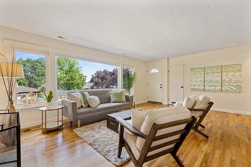 wood room with gray leather sofa, brown wooden side table, and armchairs living room