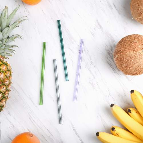 fruit four assorted-color straws beside fruits plant