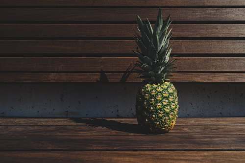 fruit green and yellow pineapple placed on brown wooden pallet bench pineapple