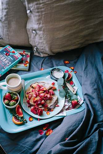 breakfast pastry top with strawberries beside cup of coffee pancake