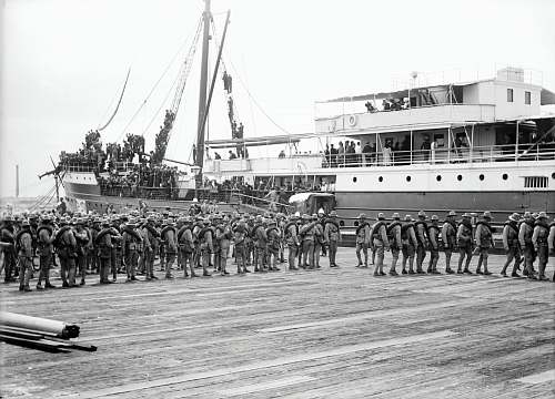 person grayscale photography of soldier marching beside passenger ship black-and-white
